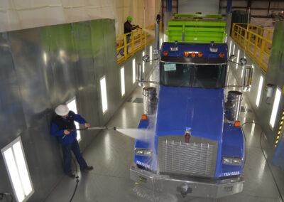 Blue and green semi truck getting washed