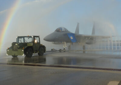 Military aircraft being rinsed with the clear water rinse system with a rainbow in the background