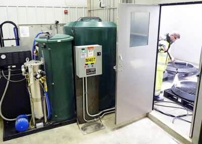 Man using intermediate water treatment system to wash equipment