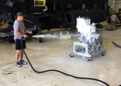 Man Using in-hangar aircraft washing system on small machine