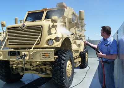 Close up side angle of person washing military tank