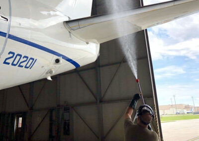 Person using in-hangar wingman on bottom of a plane wing