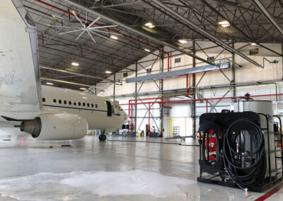In-hangar wingman next to jet in large warehouse
