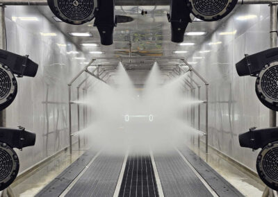 Rain testing system blasting water on vehicle