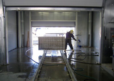 Concrete Form Wash Inside, person washing a large concrete form inside metal wash bay