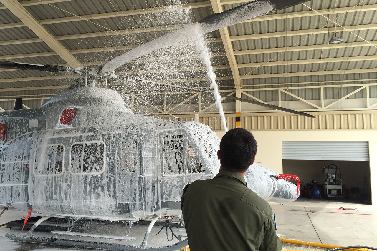 Person using In Hangar Wingman to wash helicopter